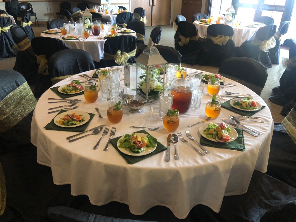 Elegant place settings with china, glassware, and green linen napkins