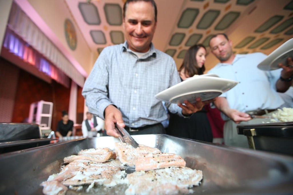 A catering staff member serving salmon at the Hall of Mirrors reception