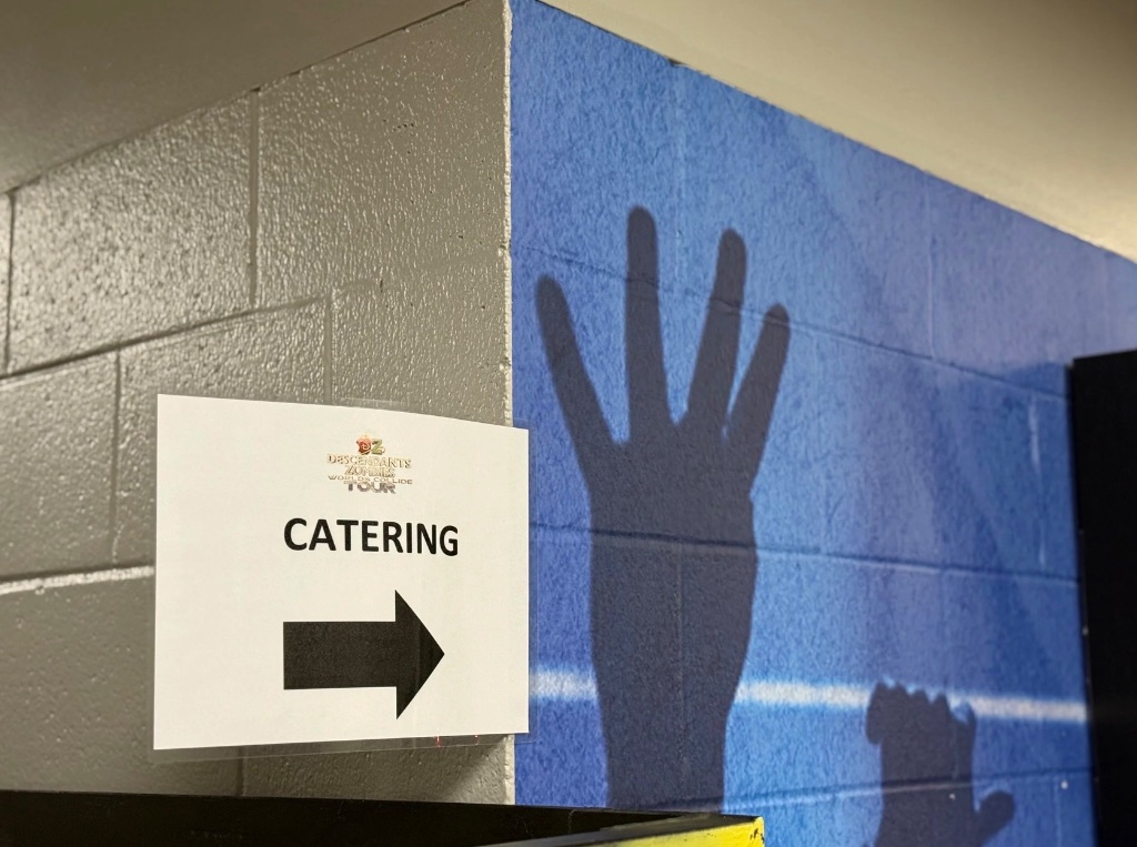 Catering directional sign backstage at the Descendants & Zombies tour