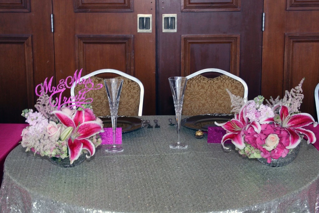 The sweetheart table set for Mr. & Mrs. Trout with pink floral centerpieces