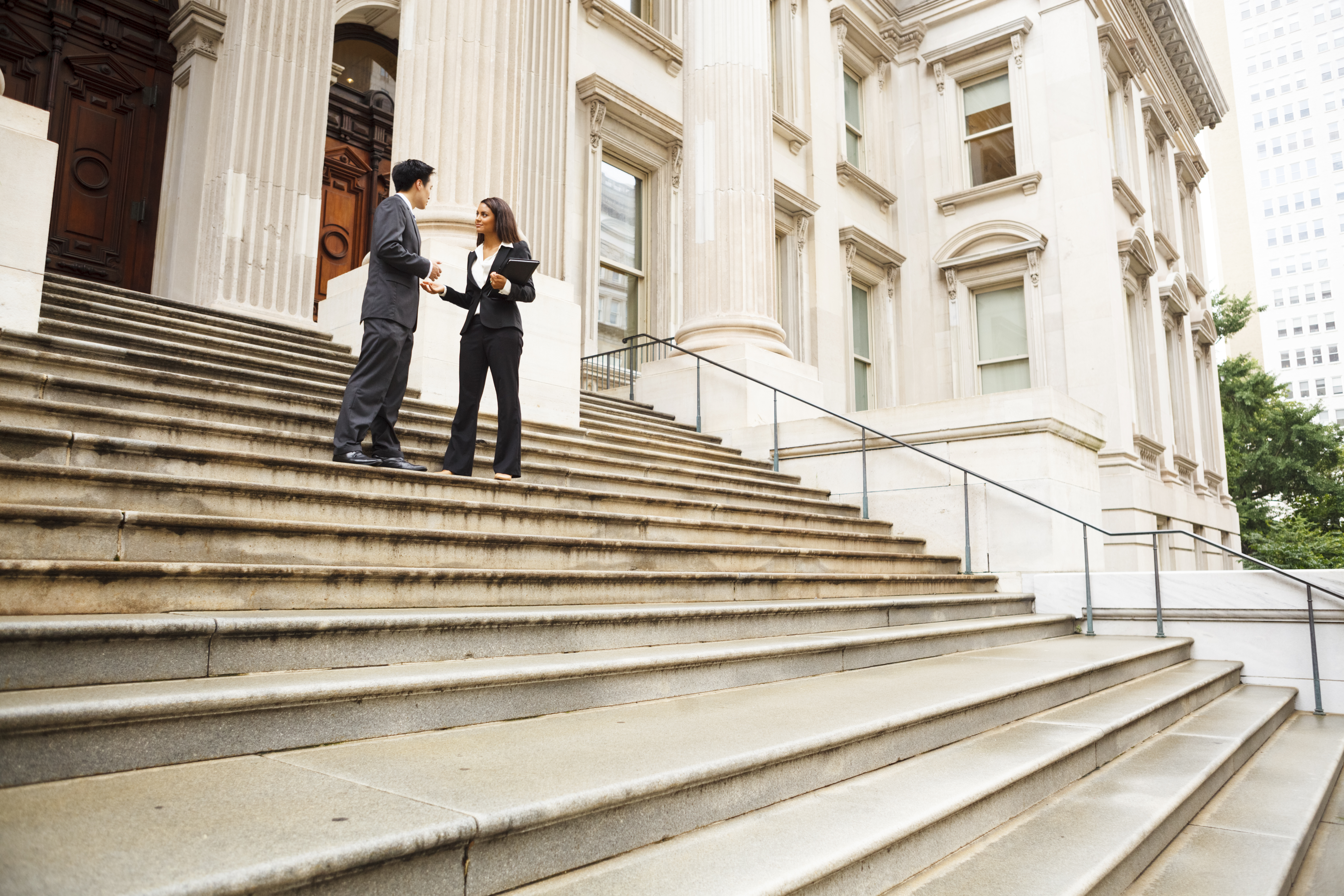 Legal professionals discussing outside courthouse