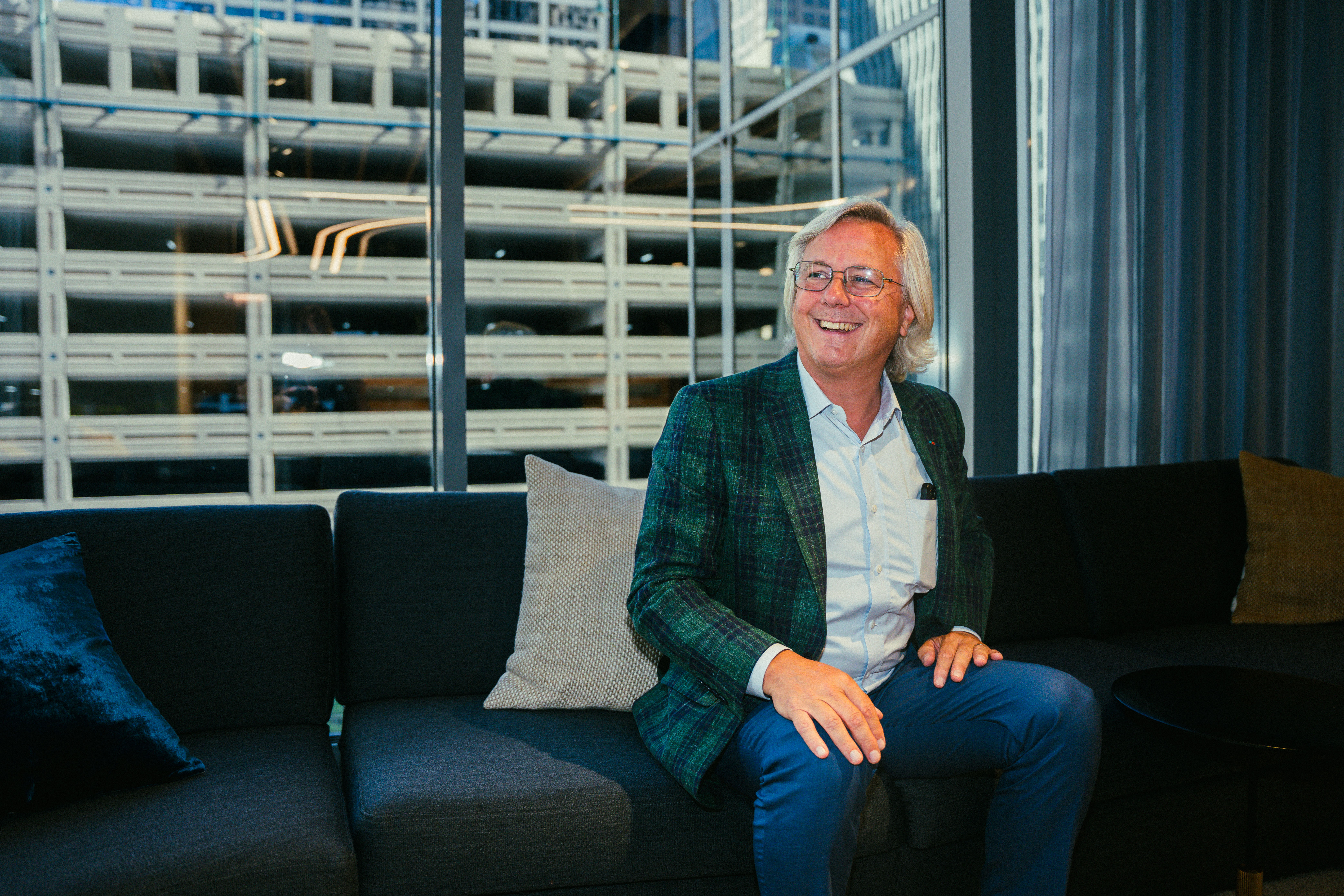 Michael P. McCready smiling while seated on a sofa in the office