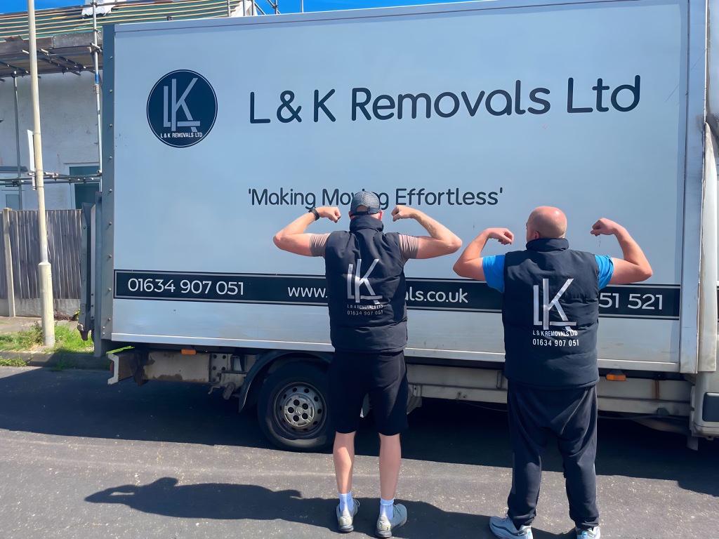 L&K Removals team flexing in front of branded removal truck