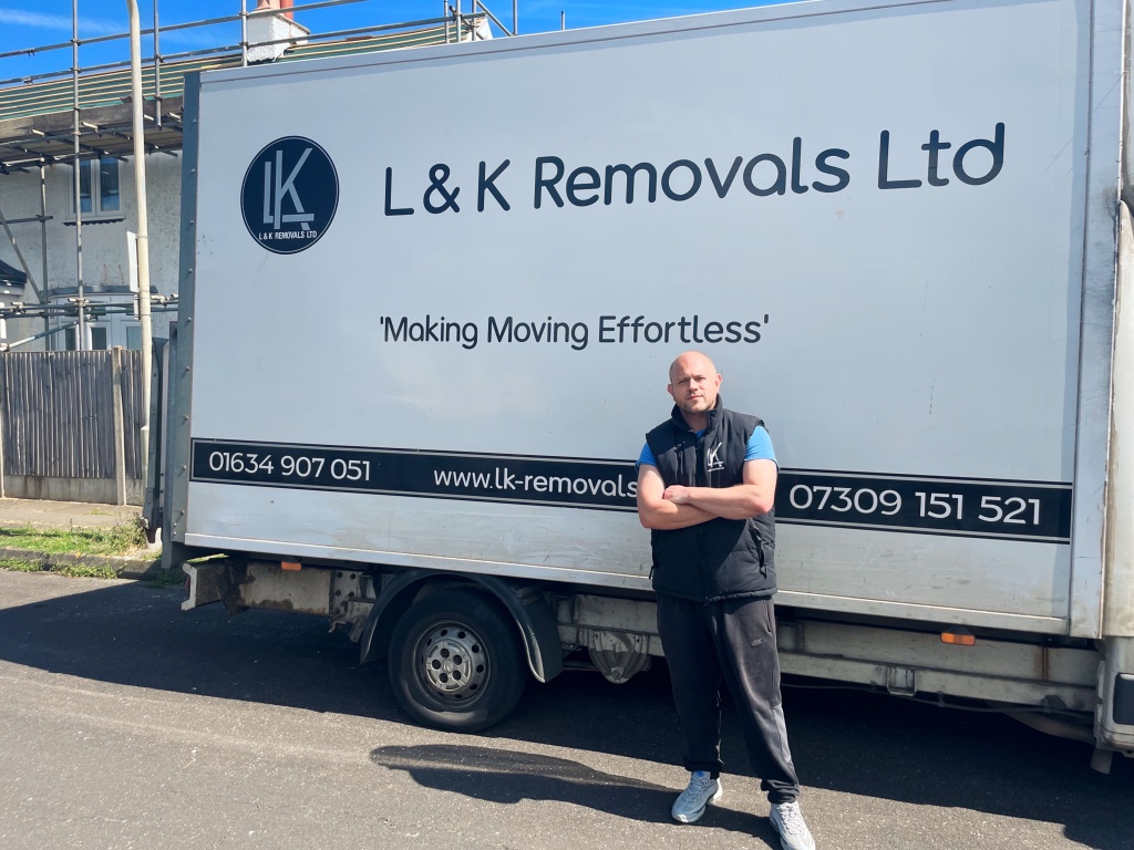 L&K Removals team member confidently beside branded removal truck