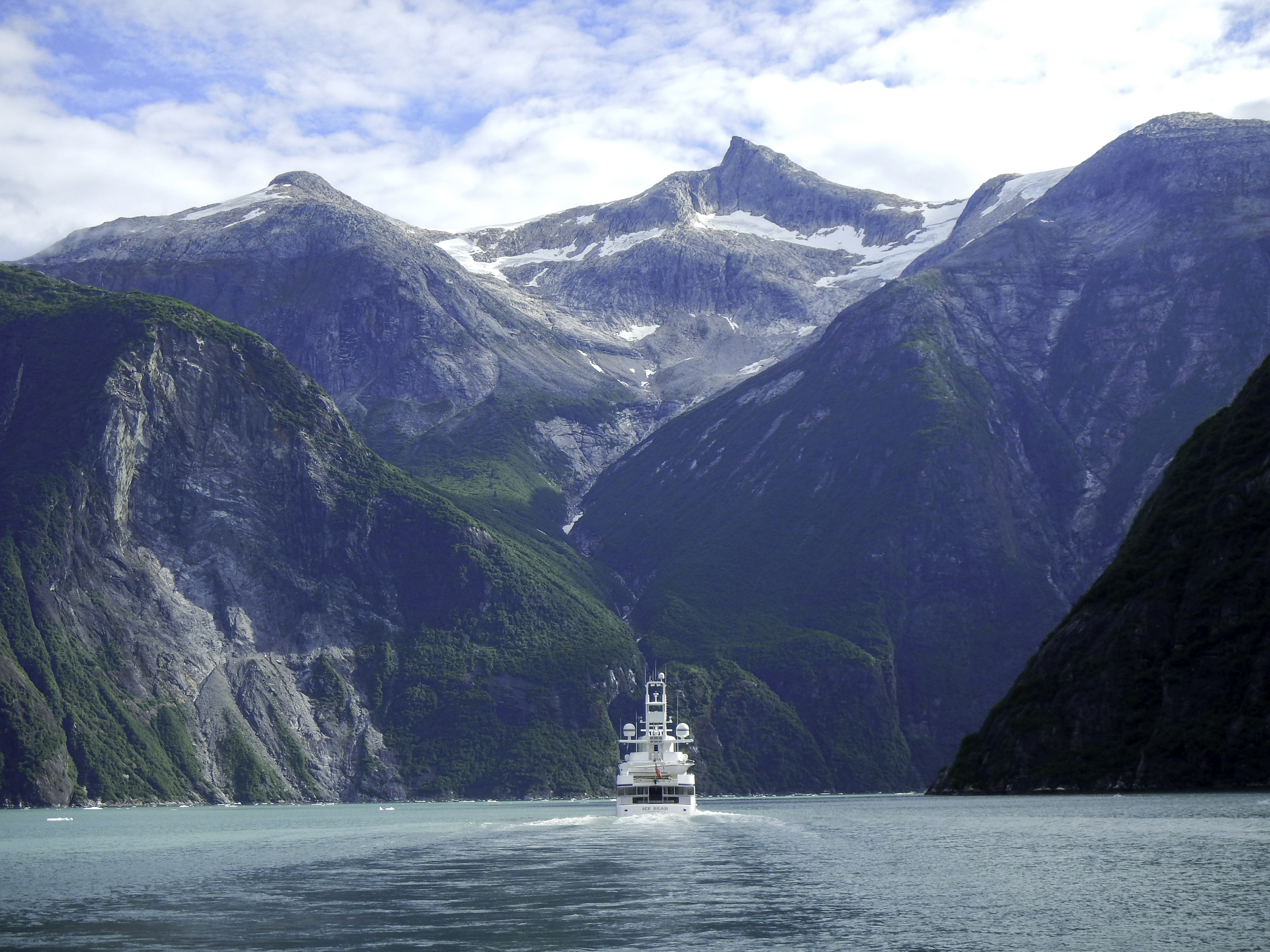 Yacht cruising through a Pacific Northwest fjord