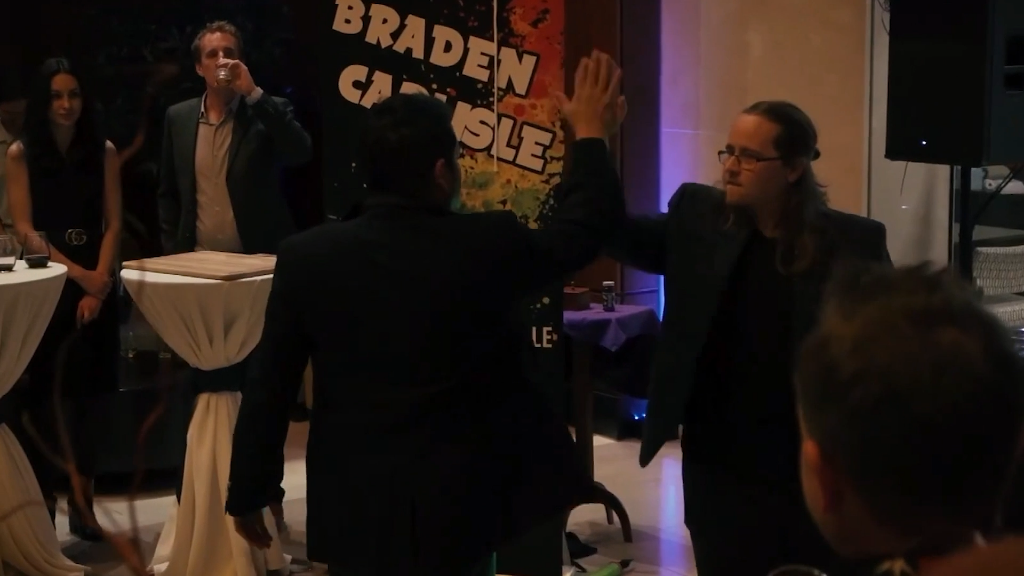 Braden Carlisle high-fiving an audience member on stage