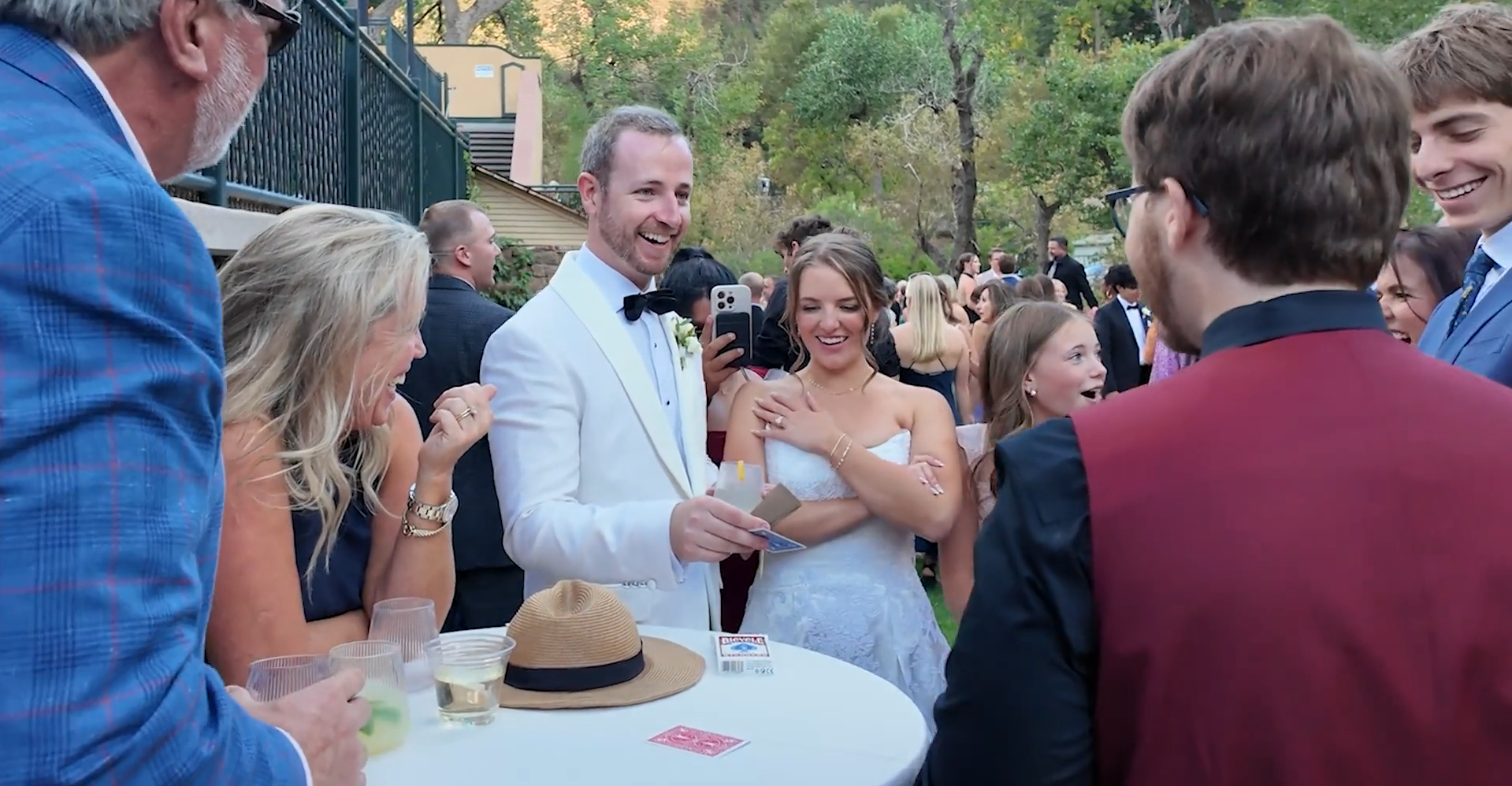 Braden Carlisle performing close-up magic for a bride and groom at their wedding cocktail hour