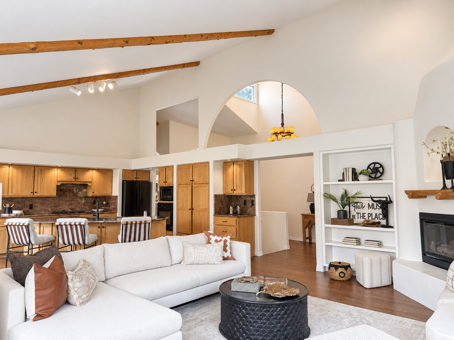 Open concept living and kitchen with vaulted ceiling and wood beams at 10276 Totem Run — Littleton Colorado foothills home