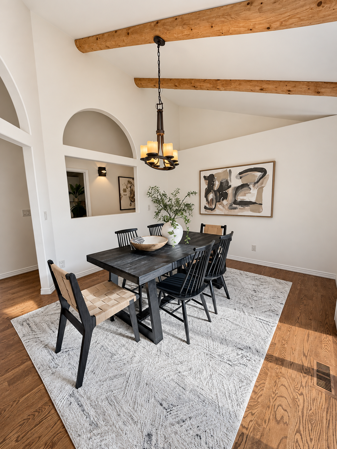 Dining room with black chandelier and exposed beams at 10276 Totem Run — Colorado foothills home for sale in Littleton