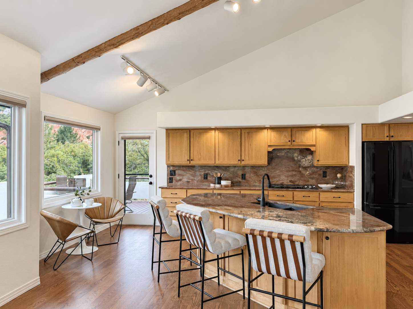 Kitchen with oak cabinets, stone island and bar seating at 10276 Totem Run, Roxborough Park Littleton CO