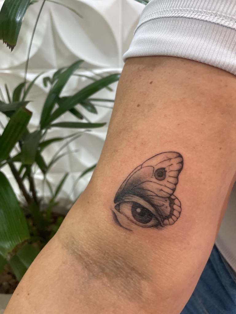Butterfly eye tattoo on arm