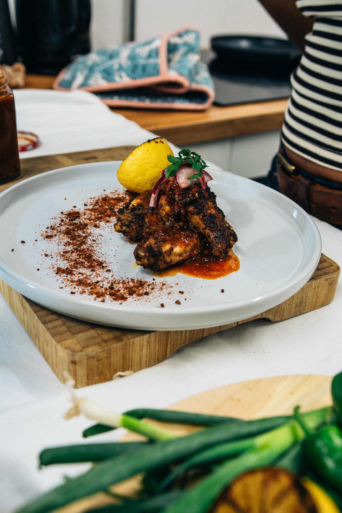 Glazed chicken wings plated with sauce and garnish
