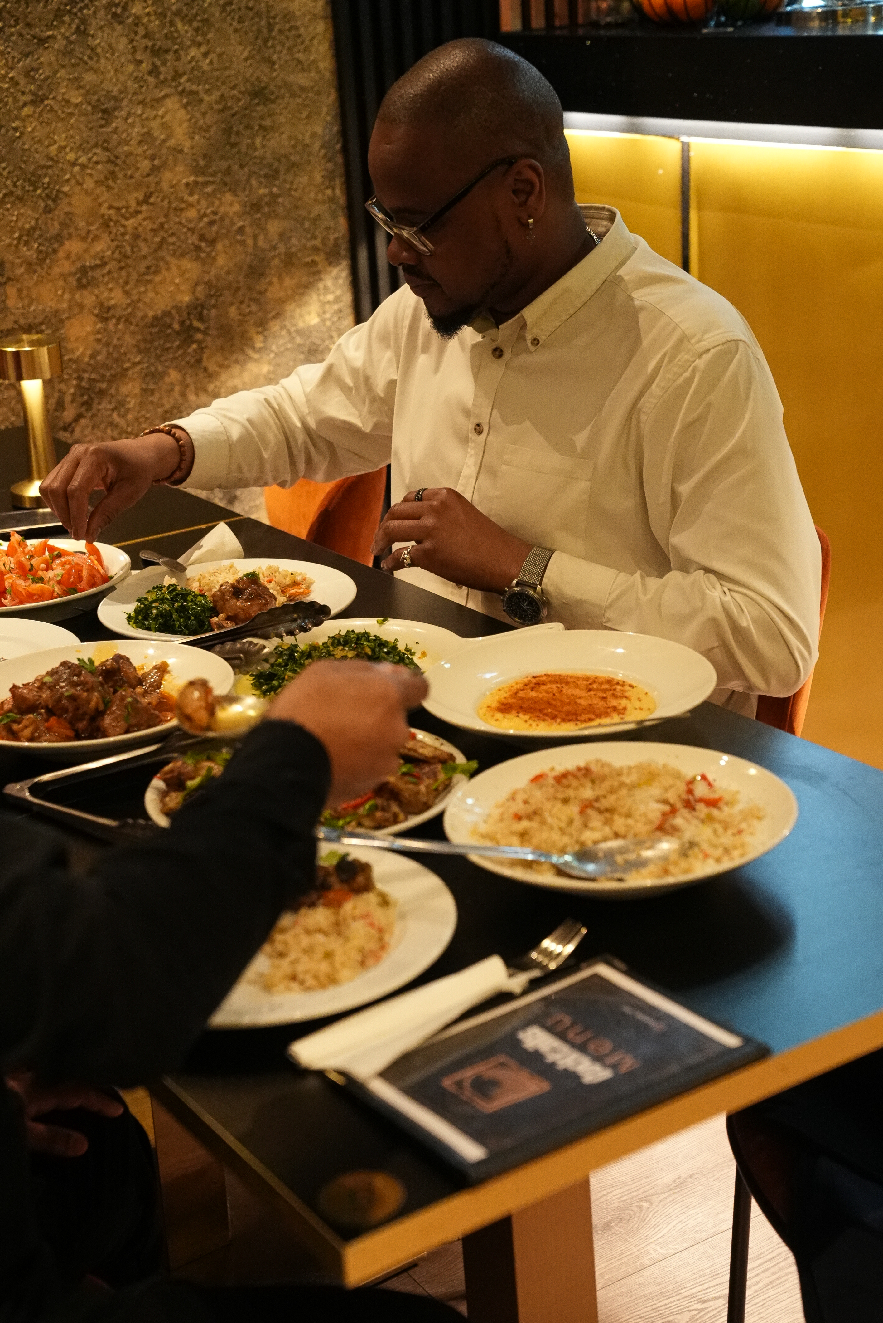 Guests sharing a meal around the Kumba table