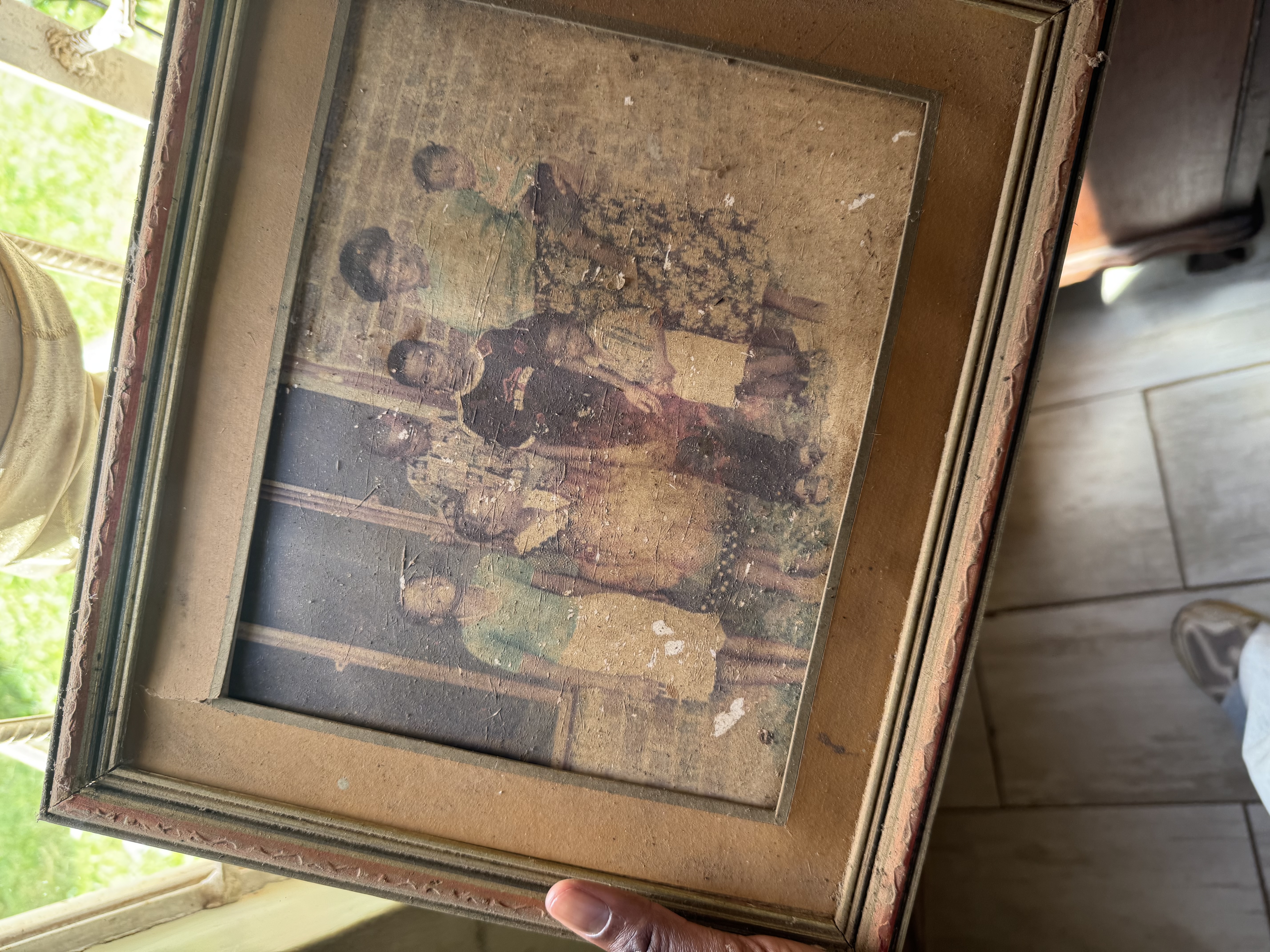 A weathered sepia photograph of four children, held in a vintage frame