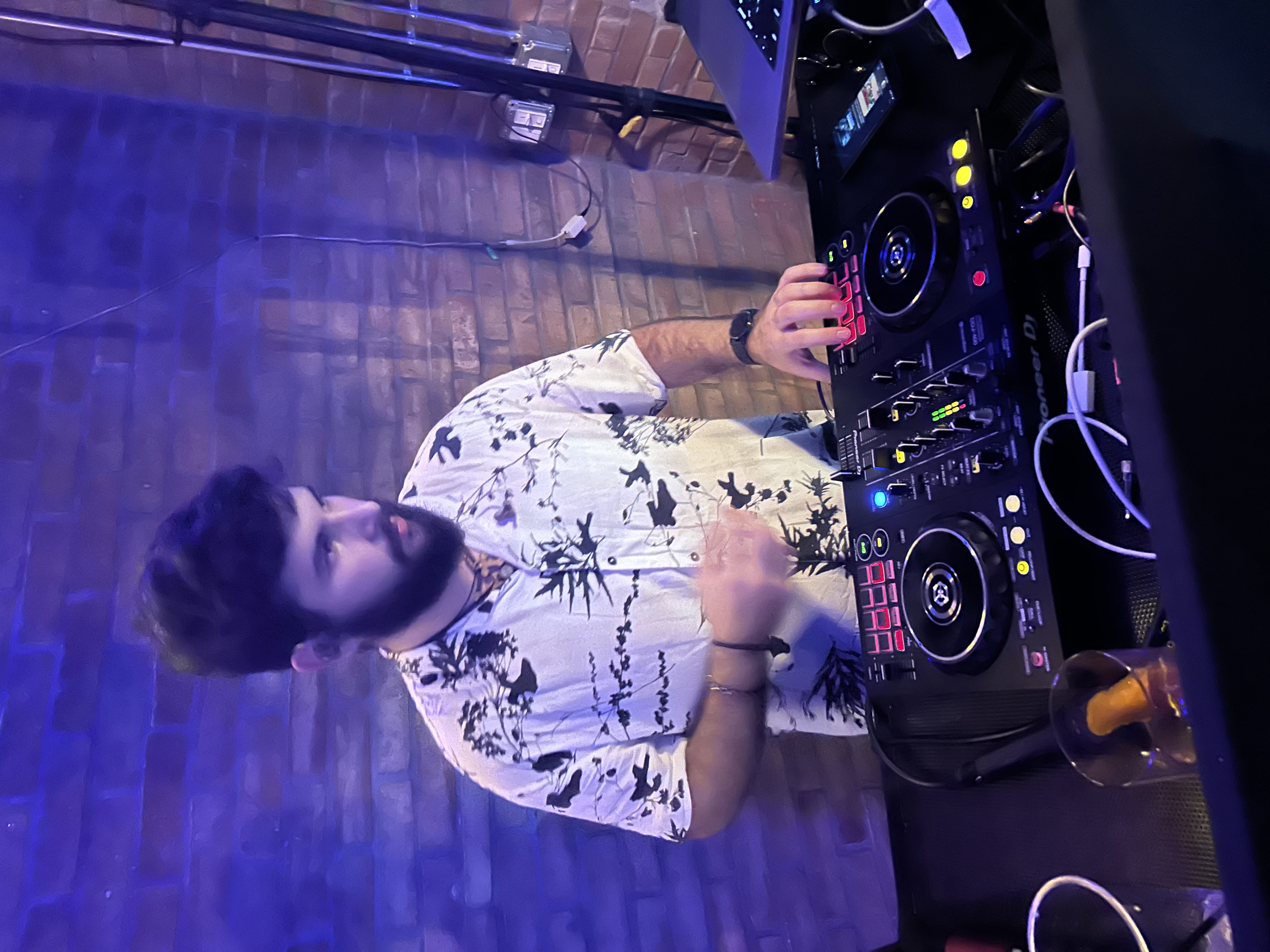 DJ performing at a live event with blue and purple lighting