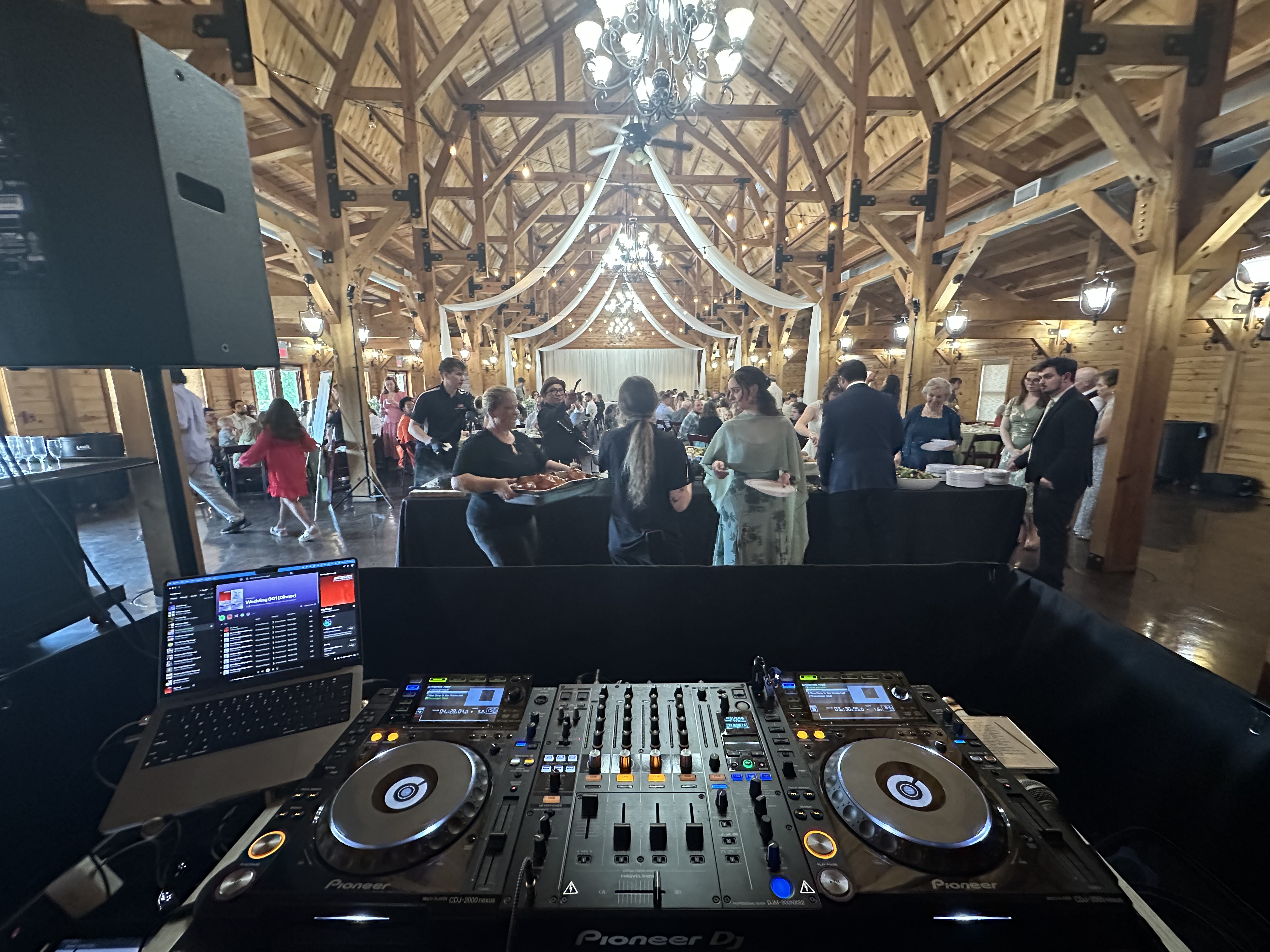 Elegant event venue with a professional DJ setup and guests celebrating