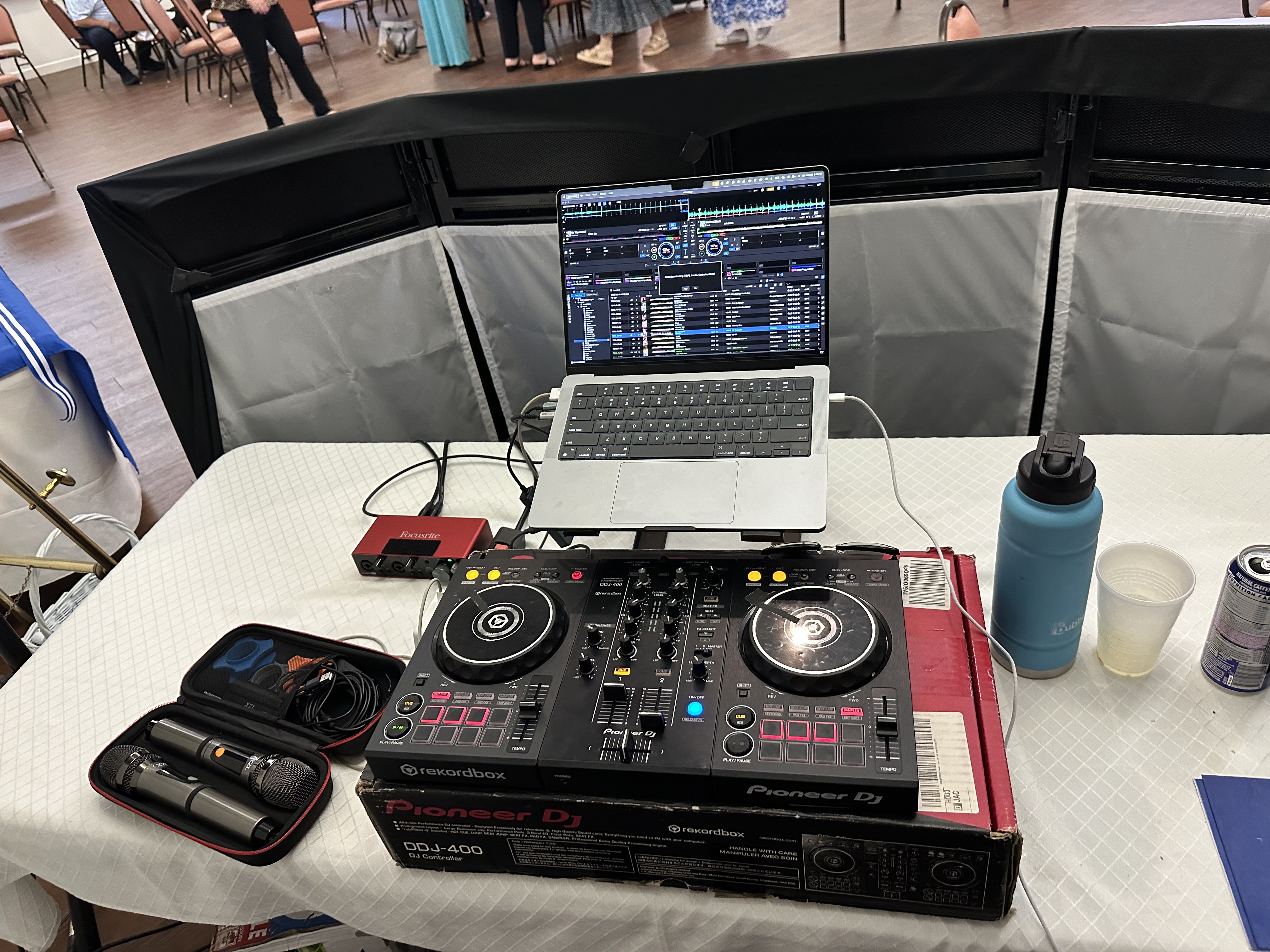 DJ controller, laptop, and equipment setup at a formal event