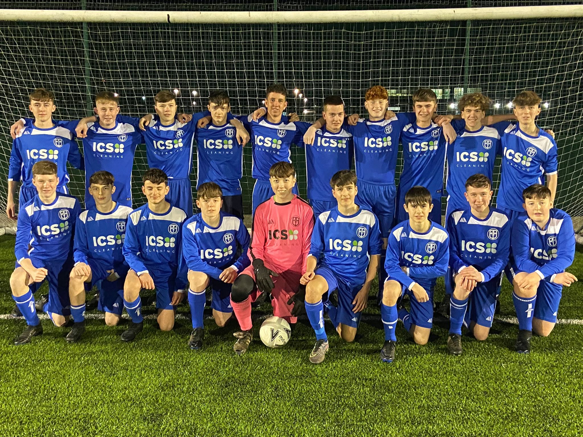 Junior football squad wearing blue ICS Cleaning sponsored shirts