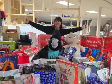 A colleague surrounded by donated Christmas gifts, toys and presents collected for local families