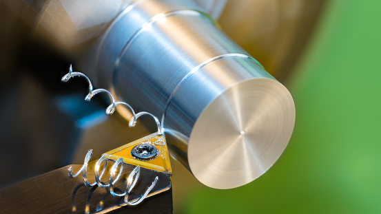 Closeup of turning cylindrical workpiece on lathe