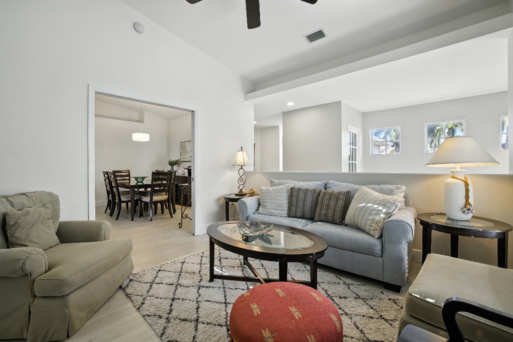 Bonus room with pull-out sofa seating area and view into dining room at Pinnacle, Unit 2503 Naples FL