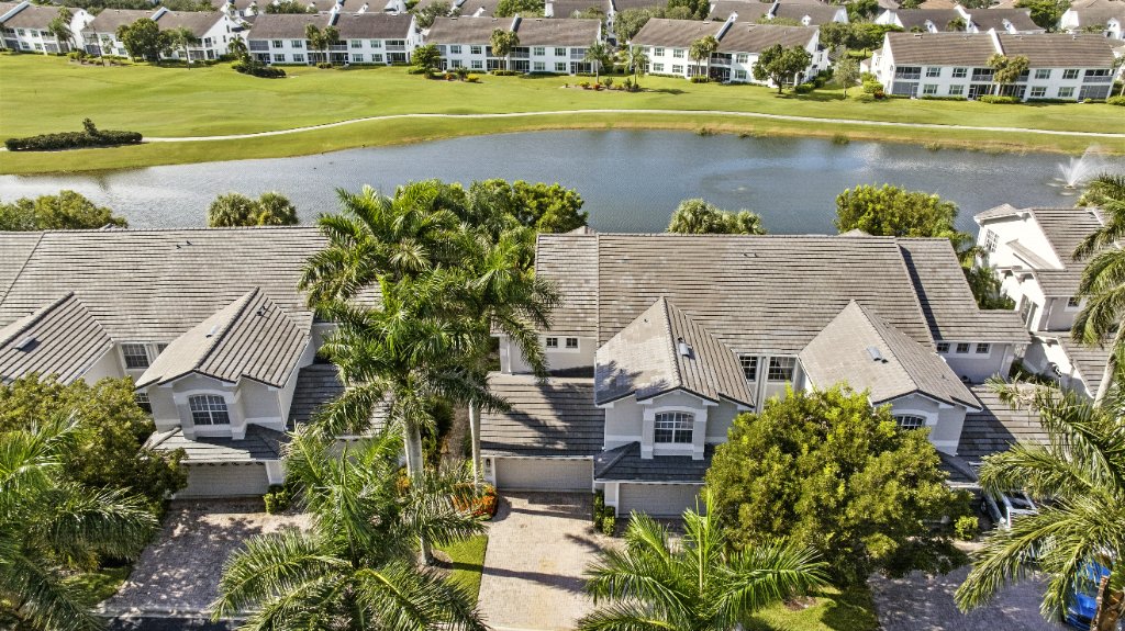 Aerial exterior view of Pinnacle, Unit 2503 townhome with lake and golf course at The Strand Naples FL