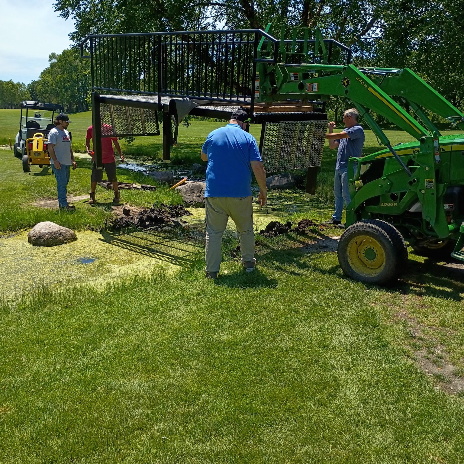 FOX Welding crew positioning the fabricated pedestrian bridge during installation at the golf-course property.