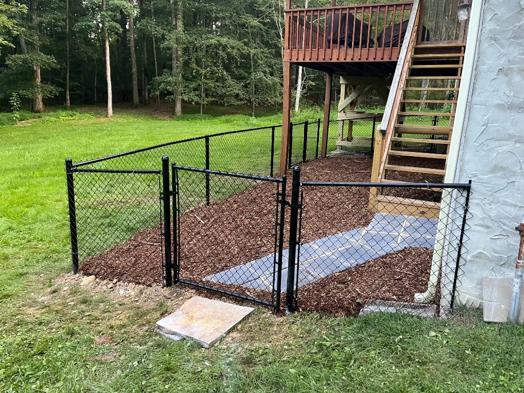 Black chain-link fence with mulch bed installation