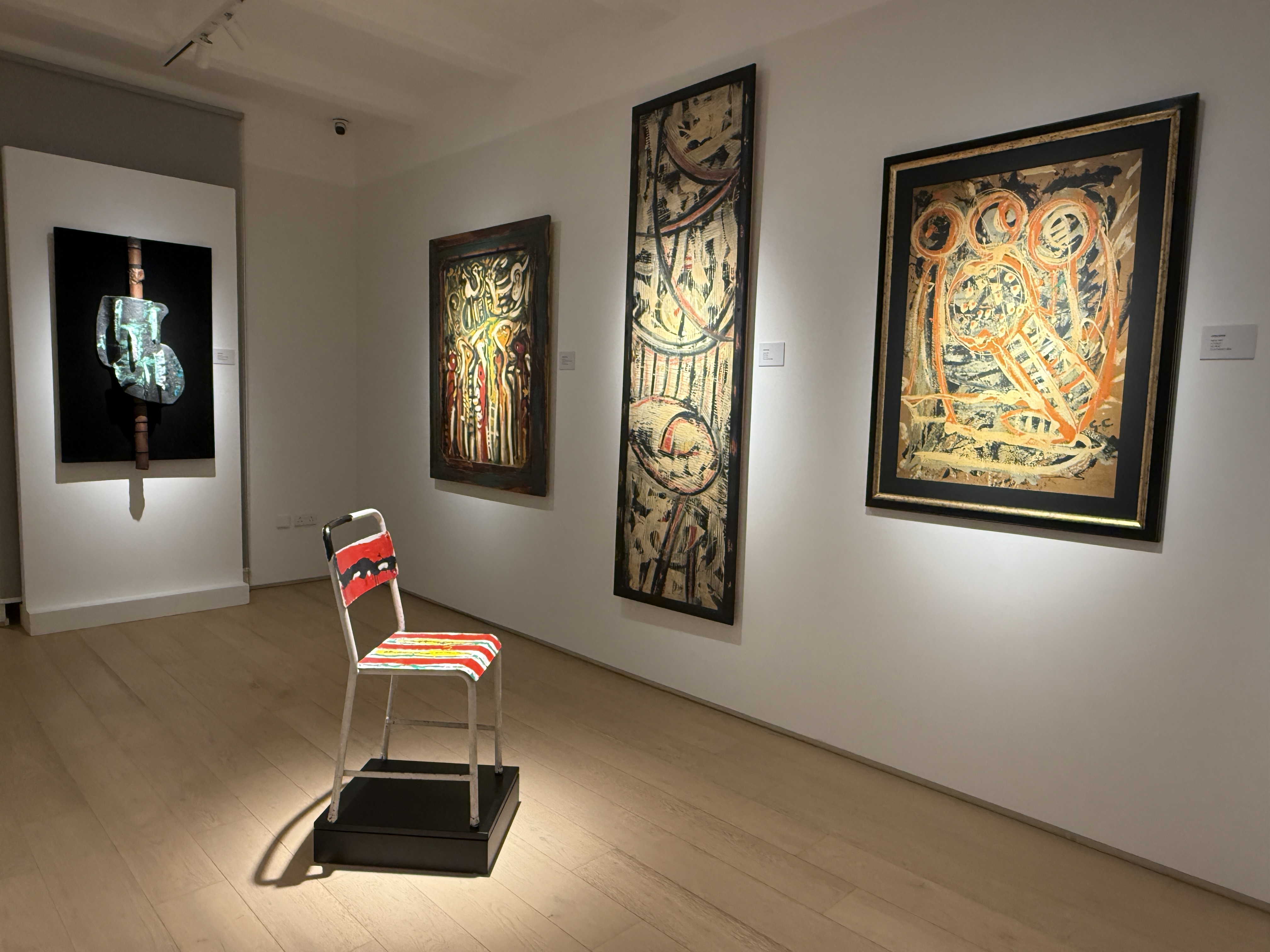 Installation view of Gabriel Caruana exhibition at the Victor Passmore Gallery with painted metal chair on pedestal and abstract artworks on walls