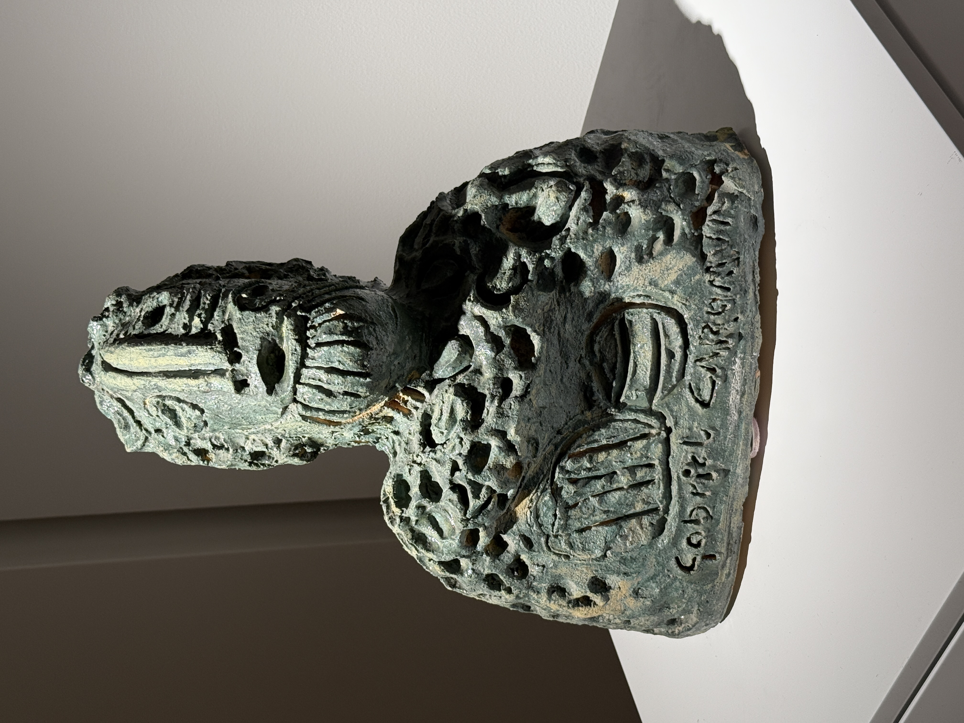 Dark grey-green ceramic sculpture by Gabriel Caruana with pitted texture and artist signature incised on the base at the Victor Passmore Gallery Valletta