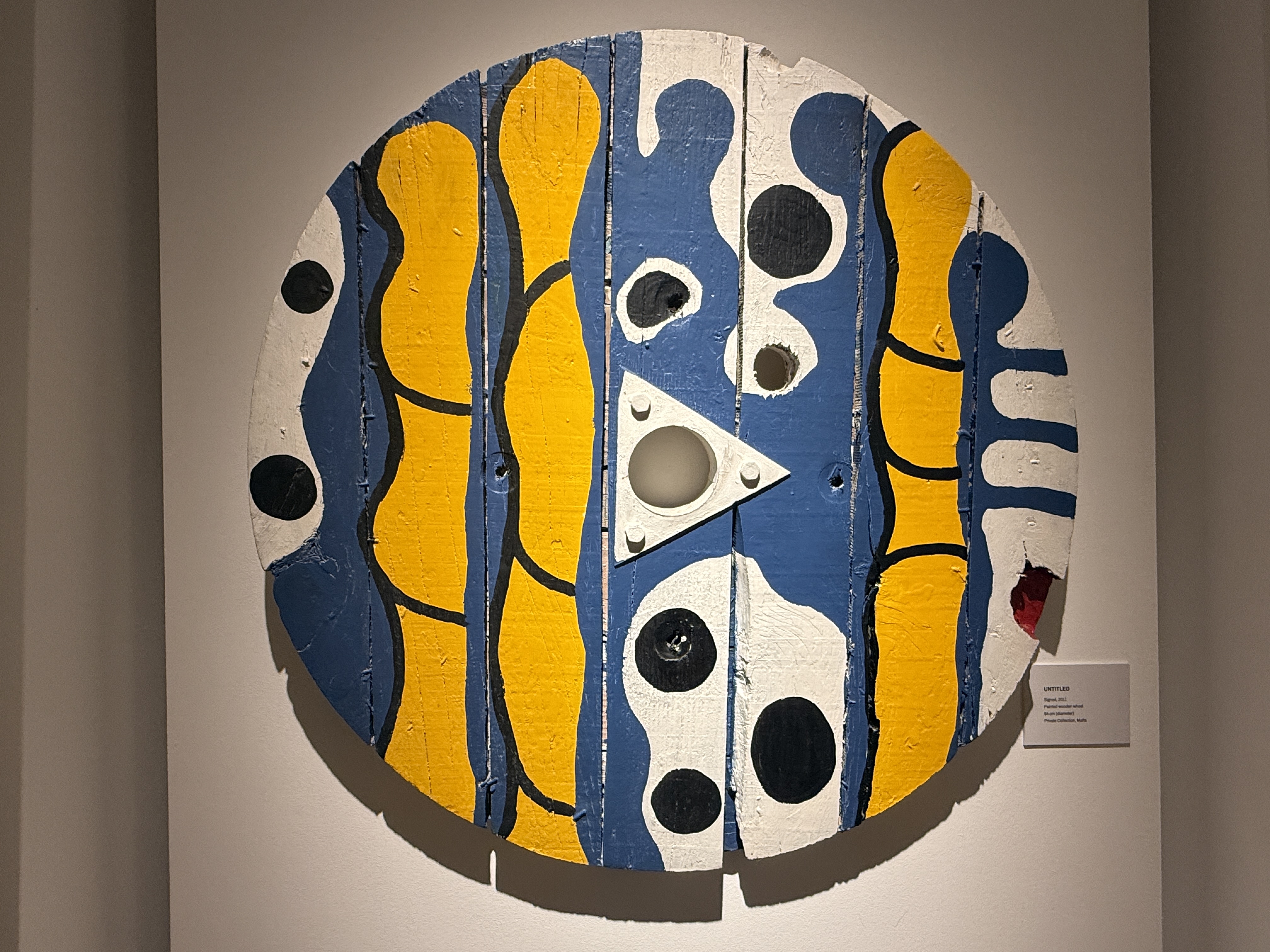 Untitled 2013 painted wooden wheel sculpture by Gabriel Caruana with blue yellow and black abstract patterns at the Victor Passmore Gallery
