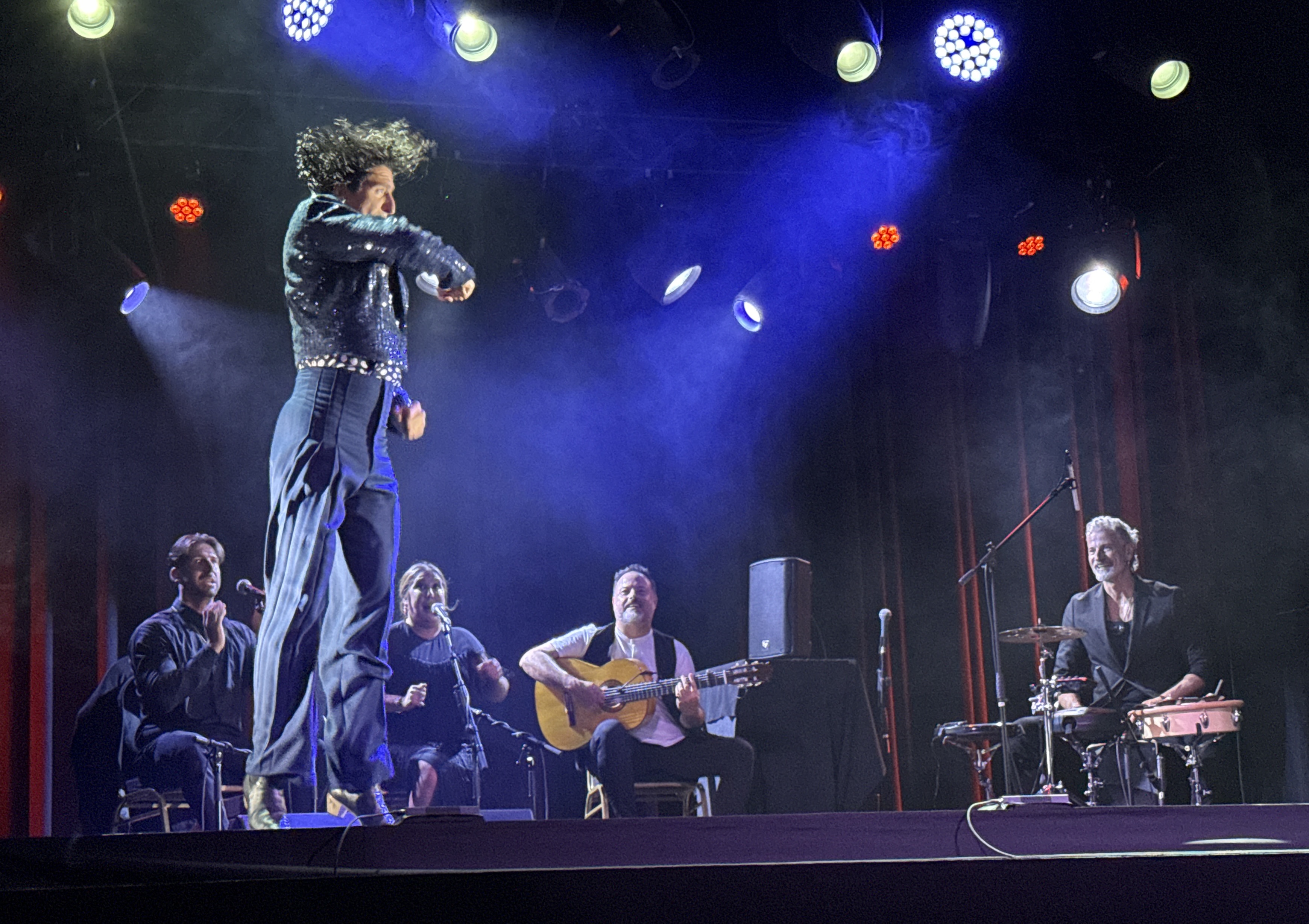 The full Puerto Flamenco ensemble under cool blue stage lighting