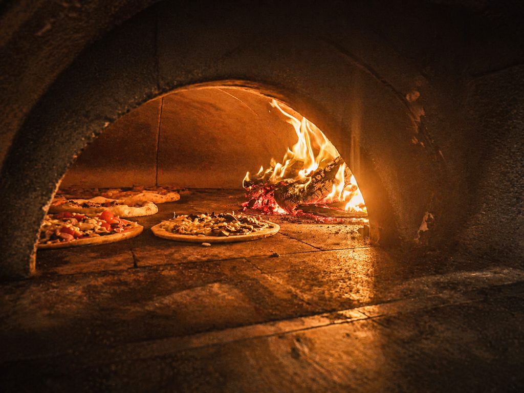 Pizzas cooking in wood-fired oven