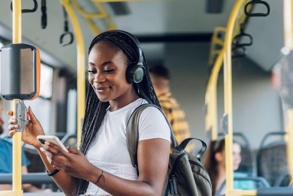 Woman on bus holding yellow pole