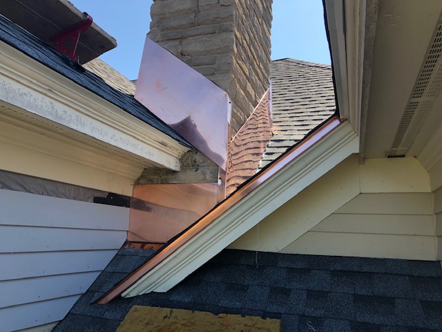 Copper step and base flashing detail at a chimney