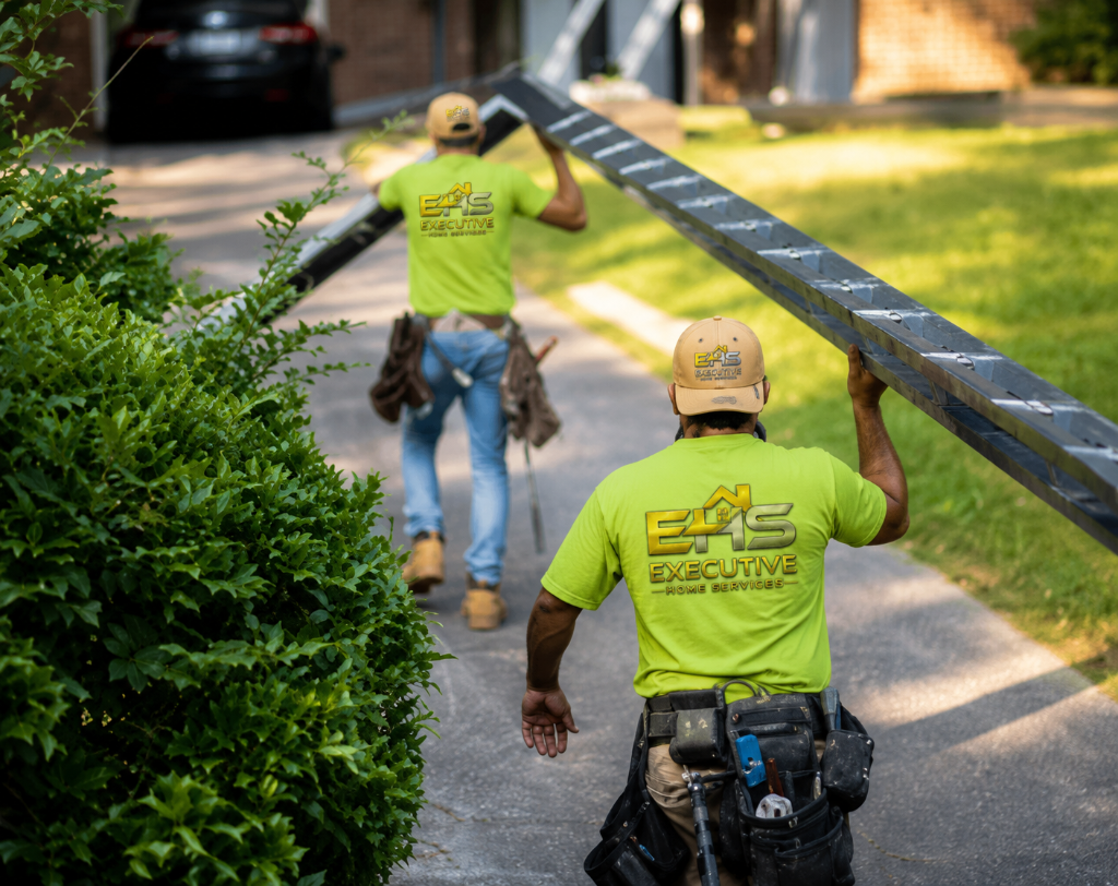 Executive Home Services crew carrying gutter material to a job site