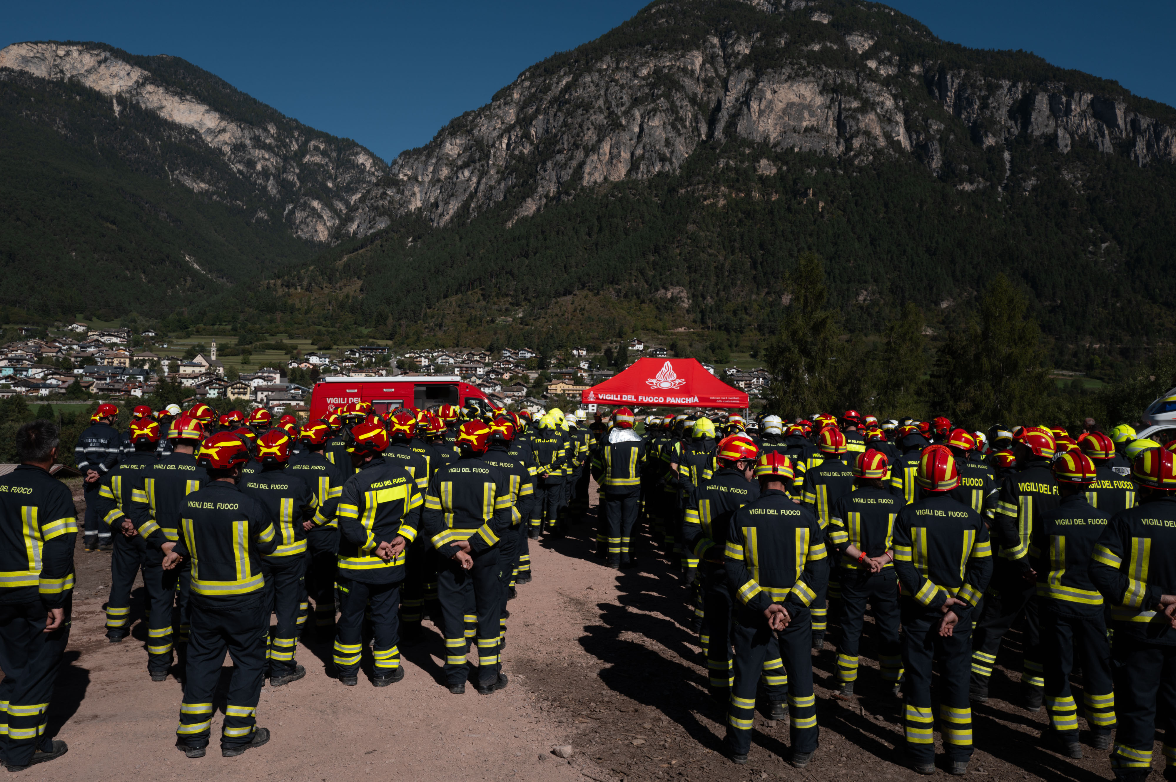 Volunteer firefighters gathered in front of the command tent during the training exercise in Val di Fiemme