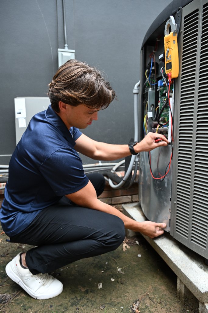 Good Neighbor Heating & Air HVAC technician repairing an air conditioning unit in Tulsa, OK