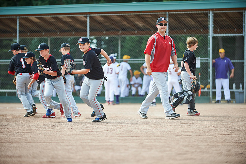 Coach and young athletes on the field