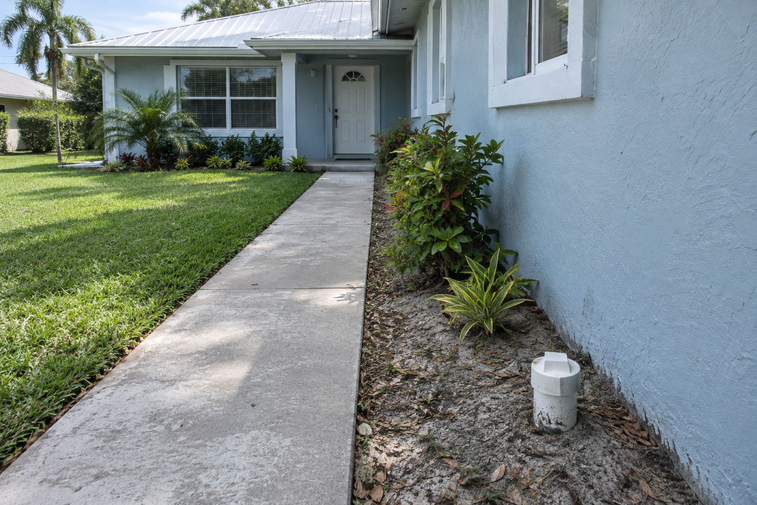 White PVC sewer cleanout at the front of a Davie home where the camera is fed into the main line