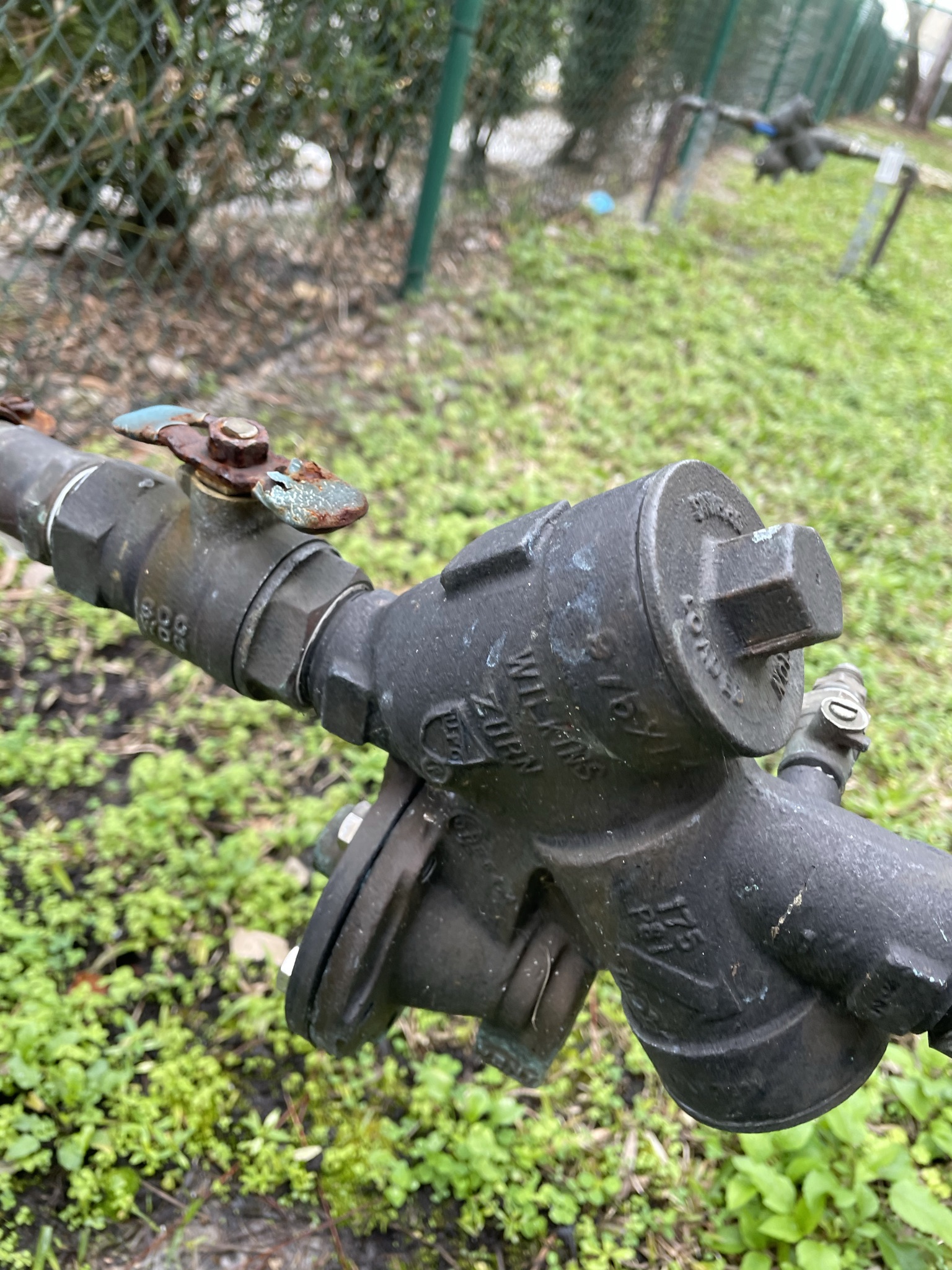 Wilkins backflow prevention assembly mounted outside with a worn brass shutoff valve handle