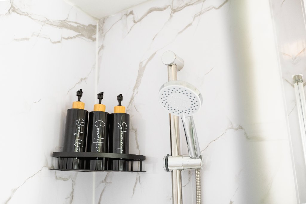 Shower with marble tiles and toiletries