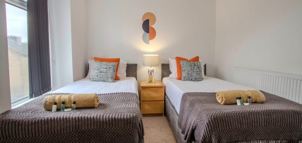 Twin bedroom with orange cushions