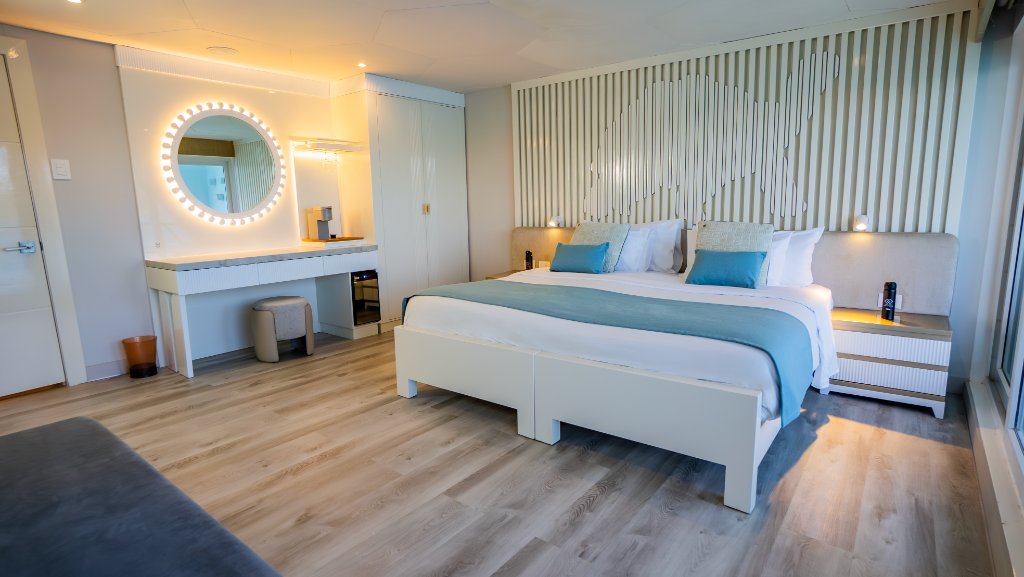 Wide view of an M/C Elite Golden Suite with modern soft blue bedding