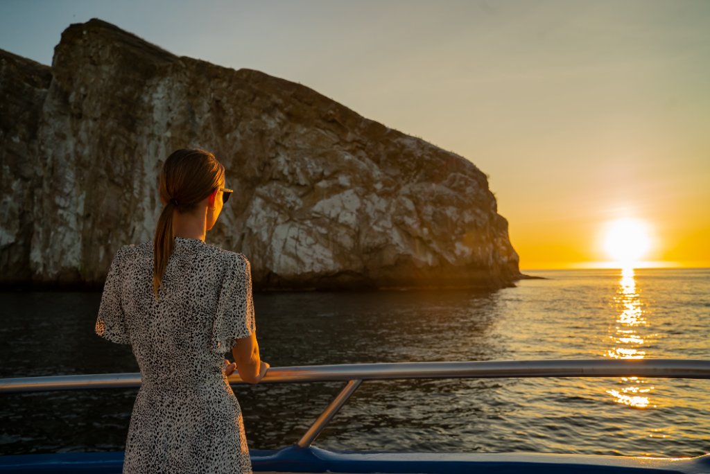 Guest watching the Galápagos coastline from M/C Ocean Spray