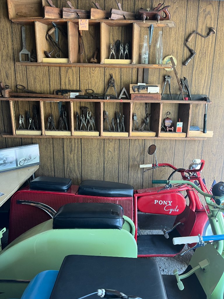 Workshop display with tools and restored scooters