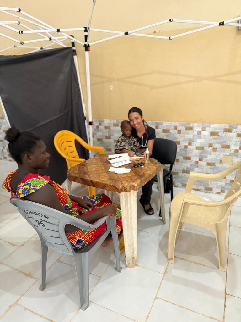 Médica voluntária atendendo mãe e bebê da comunidade