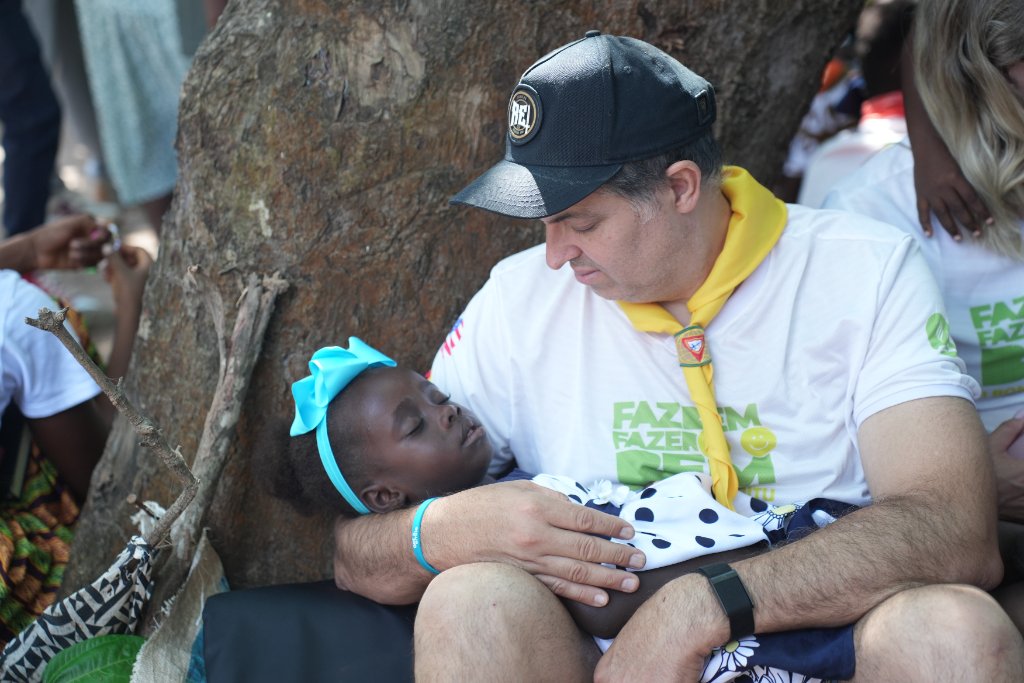 Voluntário cuidando com carinho de criança da comunidade