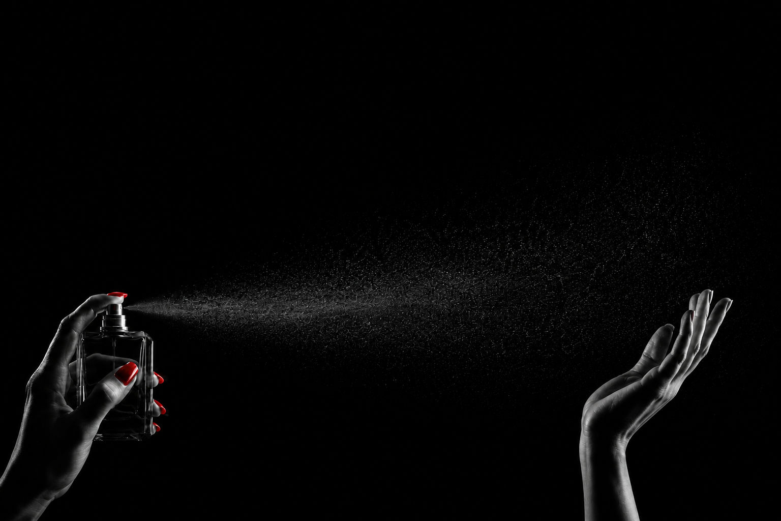 Fragrance bottle spray against a dark atmospheric background