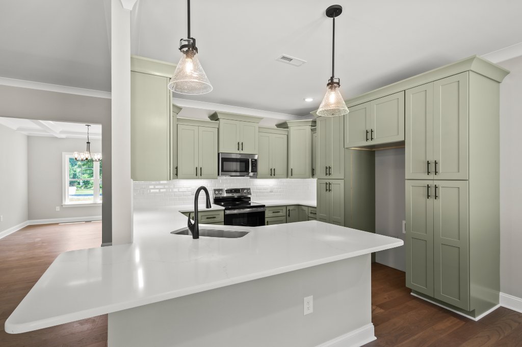 Gourmet kitchen with island and sage cabinets